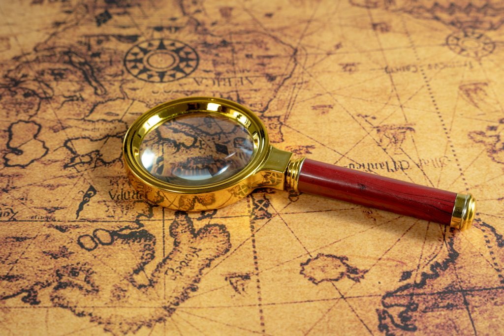 A magnifier put on the map - concept of adventures and traveling