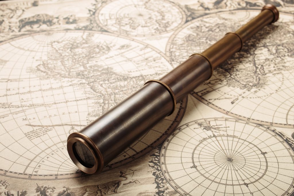 Old naval spyglass on vintage map. Adventure retro style.