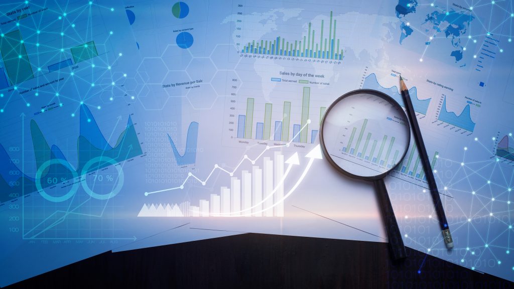 Magnifying glass and documents with analytics data lying on table , and digital virtual reality graph