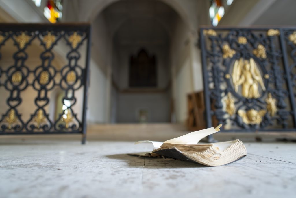 An old open book on the floor of an abandoned chapel in the Berry region, France